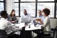 Divers group of five adults sitting around a conference table