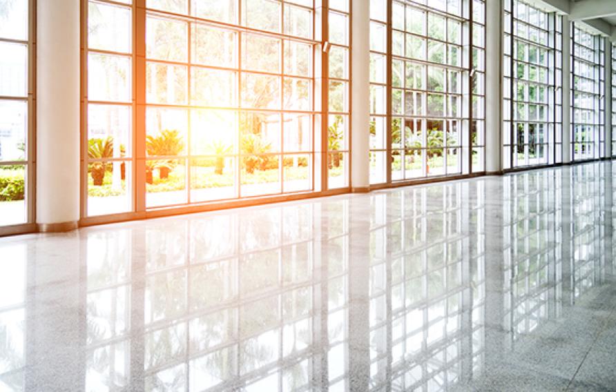 Empty lobby with glass windows and sun coming through