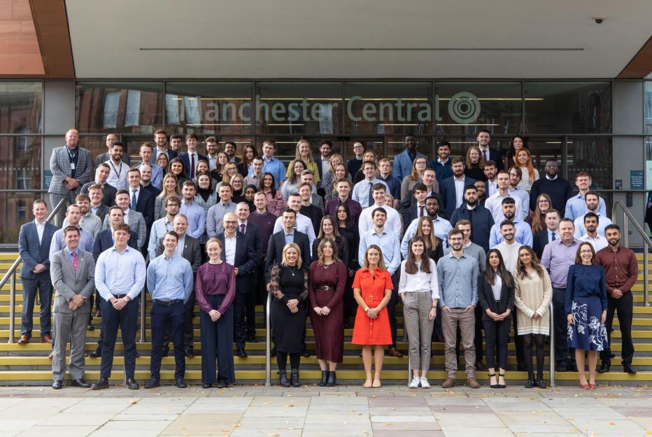 Group of our apprentices and graduates on steps in Manchester city center.