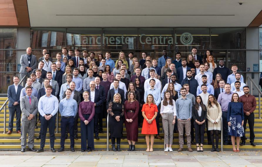 Group of our apprentices and graduates on steps in Manchester city center.