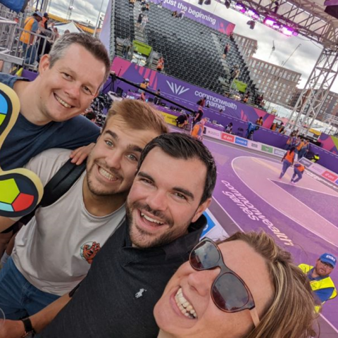 Smiling group of people pose in front of a purple sports court